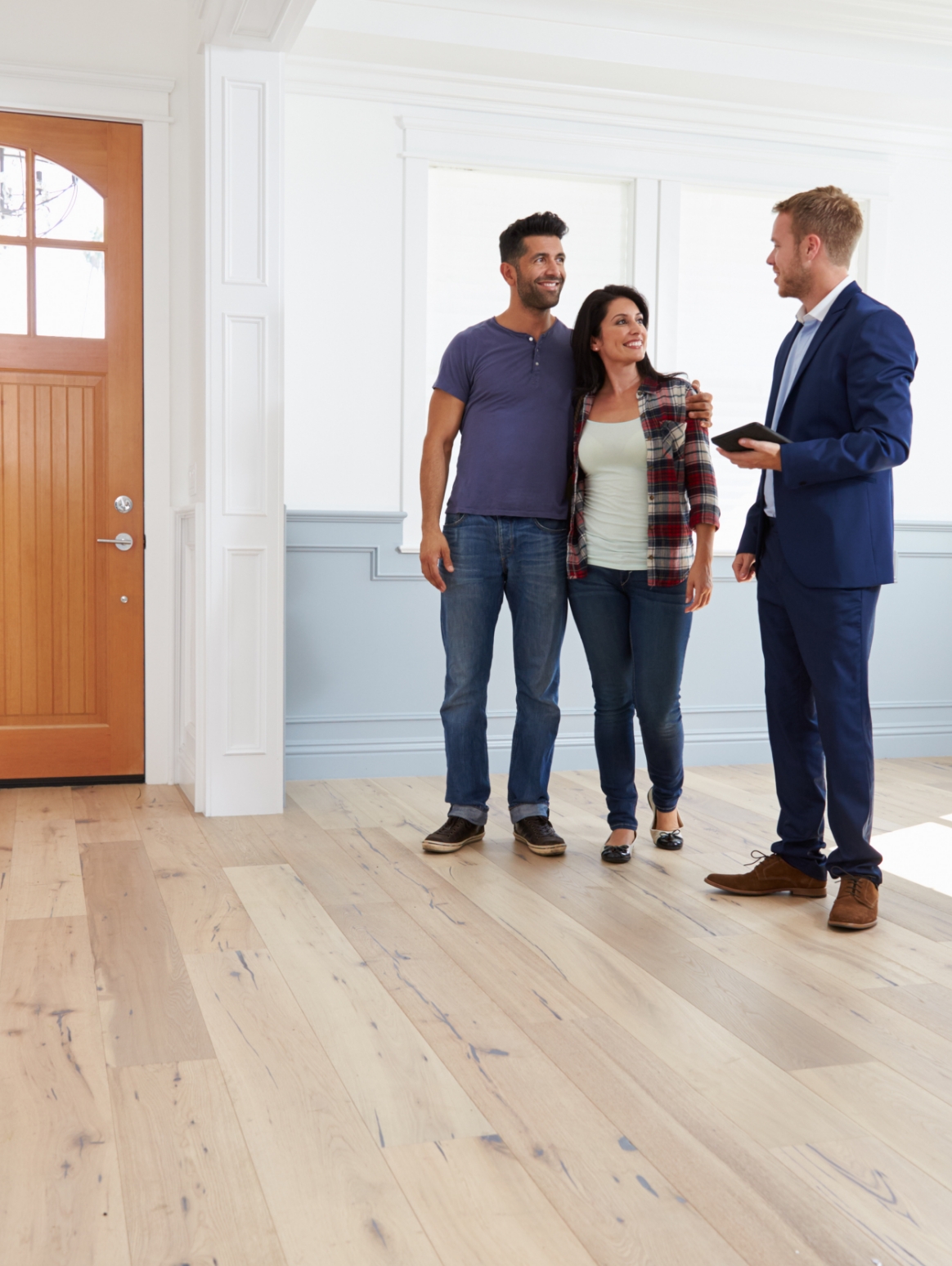 Estate agent showing a couple around a house