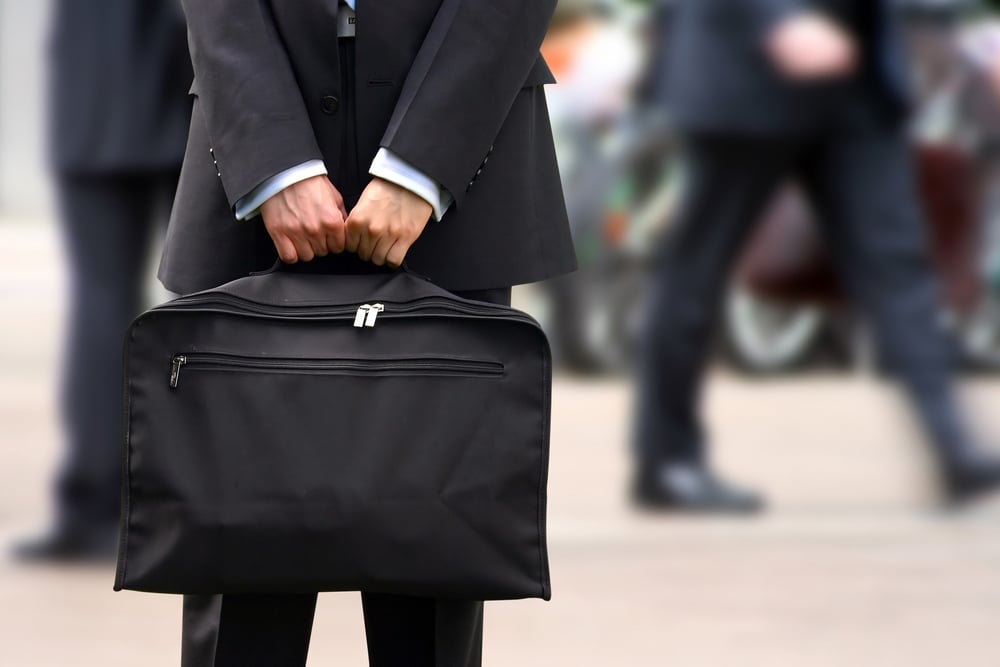 business man holding a briefcase in a fast moving corporate environment